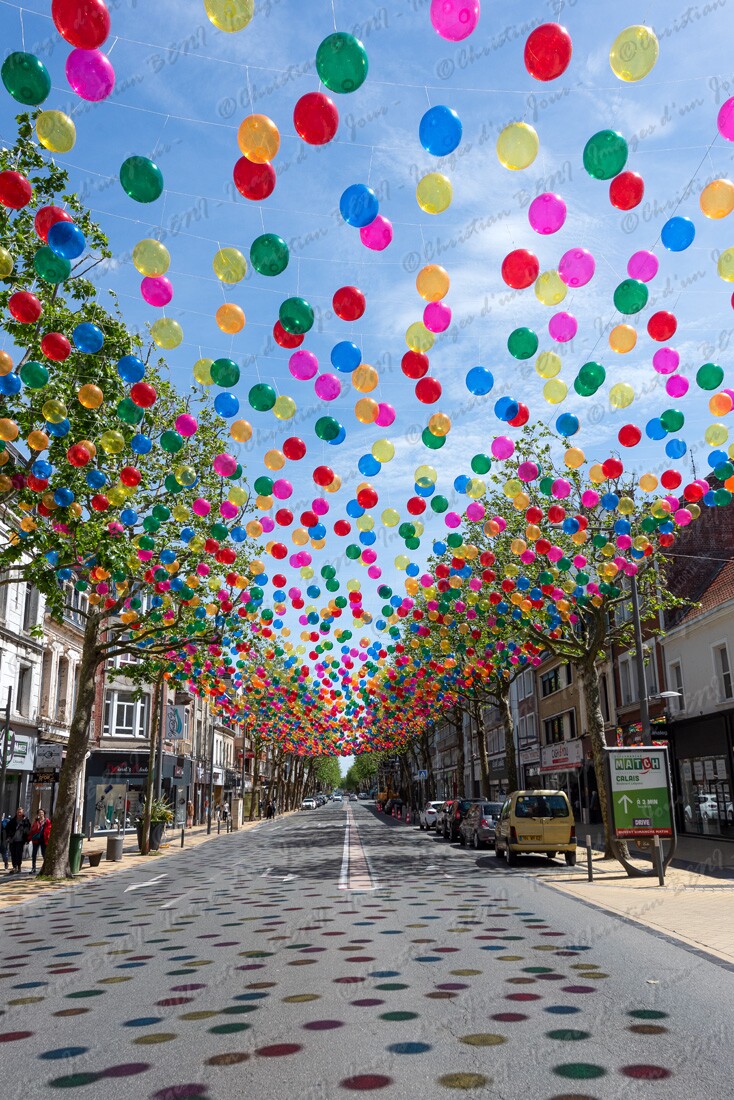CB7_8609 Les boulevards de Calais vont changer avec les décors de l'artiste portugaise Patricia Cunha. Du 28 mai au 30 septembre, des ballons et des franges de couleurs par milliers vont surplomber certains axes de la ville. Profitez en et entrez sous un ciel de bulles colorées, à bientôt...